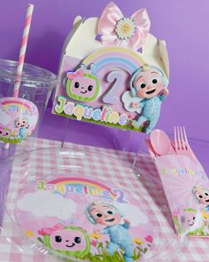 a table topped with plates and cups filled with cartoon characters next to a sign that says happy birthday