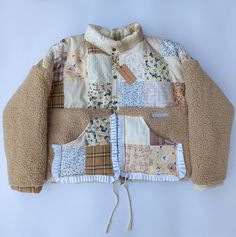 a jacket made out of patchwork material on top of a white surface with a brown cord