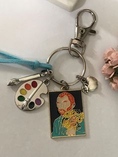 a close up of a key chain with a painting palette