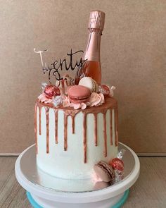 a birthday cake decorated with pink frosting and chocolate icing, topped with a bottle of champagne