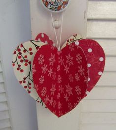 two red hearts hanging from the side of a white door with snowflakes on them