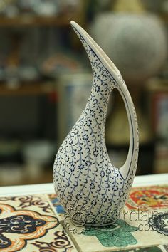 a blue and white vase sitting on top of a table