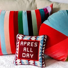 colorful pillows on a bed that say apres all day