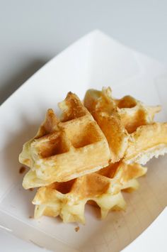 a white plate topped with waffles covered in syrup