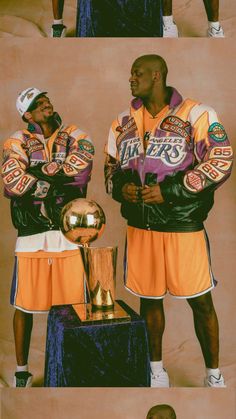 two basketball players standing next to each other in front of a trophy and another man holding the ball