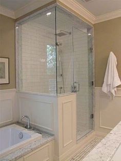 a bathroom with a walk in shower next to a bath tub