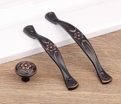 two black door handles on top of a wooden floor