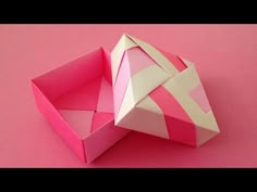 an origami box on a pink background