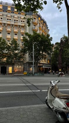 a scooter is parked on the side of the road in front of a hotel