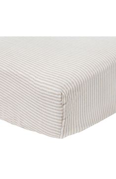 a white and grey striped sheet on a bed