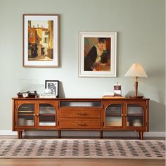 a living room with two pictures on the wall and a rug in front of it