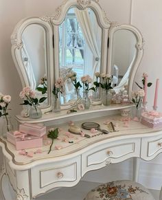 a white dressing table with flowers on it