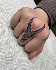 a person's hand with a tattoo on it and an animal head in the middle