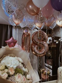 balloons and flowers are on the table in front of a number five balloon bouquets