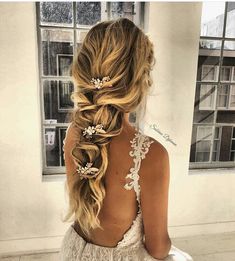 the back of a woman's head with long hair and flowers in her hair