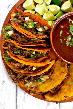 a platter with tortillas, salsa and lime wedges