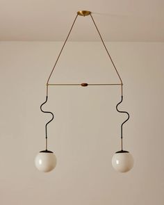 two light fixtures hanging from a ceiling in a room with white walls and flooring