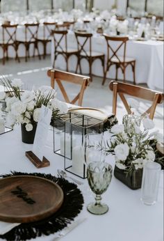 the tables are set with white flowers and place settings for guests to sit down at