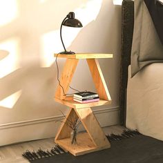 a small wooden table with a lamp on top