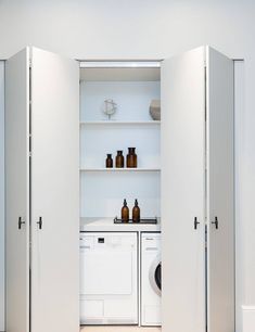 a washer and dryer in a room with open doors to the other side