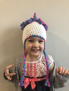 Each hat is handmade by me. This is a unicorn style messy bun hat. I use high quality ponytail holders in the top so it stretches easily over your bun. Can be made in any size and a variety of colors and with or without earflaps and ties. It is washable on a gentle cycle and air dry. Crochet Unicorn Hat, Pola Topi, Crochet Unicorn Pattern, Dragon Hats, Unicorn Hat, Cute Ponies, Crocheted Hat, Bonnet Crochet, Crochet Dragon