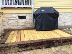 a grill cover sitting on top of a wooden deck