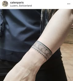 a person with a wrist tattoo on their left arm and the other hand is holding something