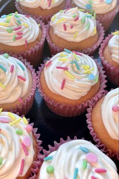 cupcakes with white frosting and colorful sprinkles