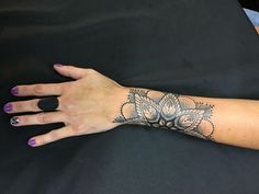 a woman's arm with a flower tattoo on the left side of her hand