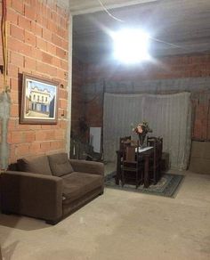 a living room filled with furniture next to a brick wall