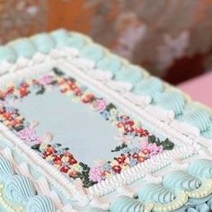 there is a cake that looks like it has been decorated with blue and pink flowers