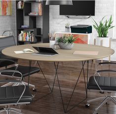 a round table with four chairs and a laptop on it in front of a bookcase