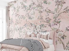 a bedroom with floral wallpaper and pink bedding