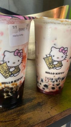 two hello kitty cups sitting on top of a table