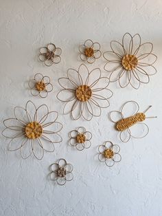 the wall is decorated with metal flowers and wire work on each flower's petals