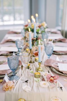 a long table is set with candles and dishes for an elegant dinner or reception party