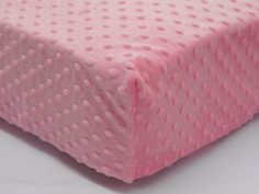 a close up of a pink bed sheet with white polka dots on the top and bottom