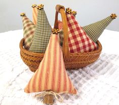 three decorative hats in a basket on a white tablecloth with a tasseled pillow