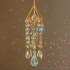 a chandelier hanging from the ceiling with colorful beads and crystal drops on it