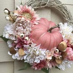 a wreath with flowers and a pink pumpkin