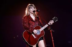 taylor swift performing on stage with her guitar