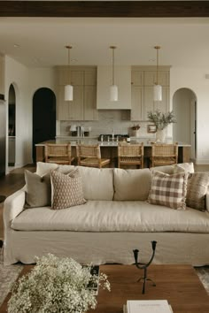 a living room filled with furniture next to a kitchen