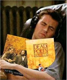 a man laying in bed while holding up a book with the title dead poets society written on it