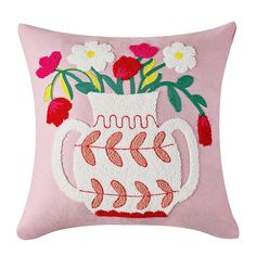 a pink pillow with flowers in a white vase on it's front and back