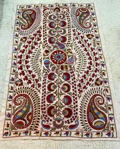 an old rug is laying on the floor with it's colorful designs and colors