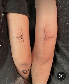 two people with matching tattoos on their legs, one has a compass and the other has an arrow