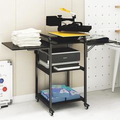 a table with a record player on it next to a stack of folded papers and a printer