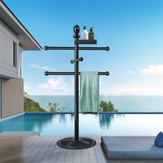 a towel rack on the outside of a house next to a swimming pool with an ocean view