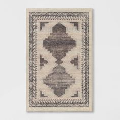 a rug hanging on the wall with a white and brown design in it's center