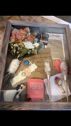 a wooden box filled with lots of different items and flowers on top of a table